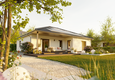 Winkelbungalow 108 aus der Gartenperspektive mit moderner Holzterrasse, geschütztem Sitzbereich und großzügigem Grundstück.